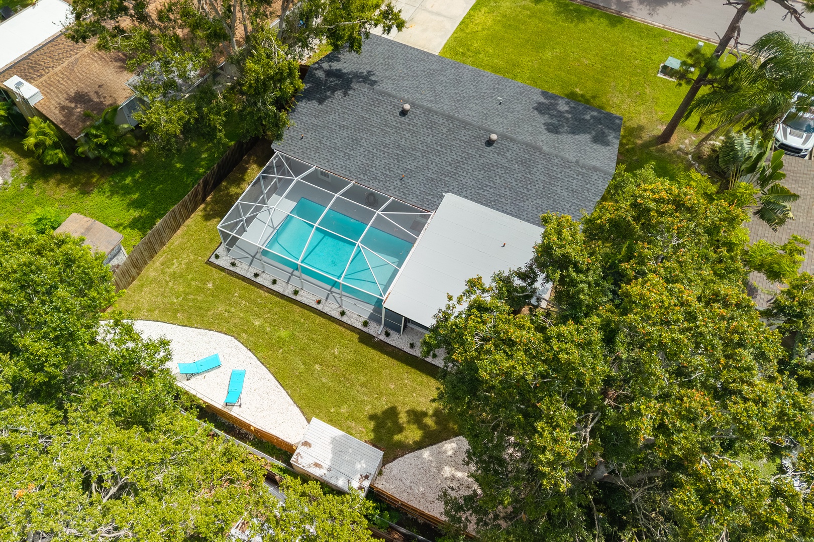Aerial view showcasing the vacation rental with screened pool area and spacious grounds surrounded by lush Florida landscaping.