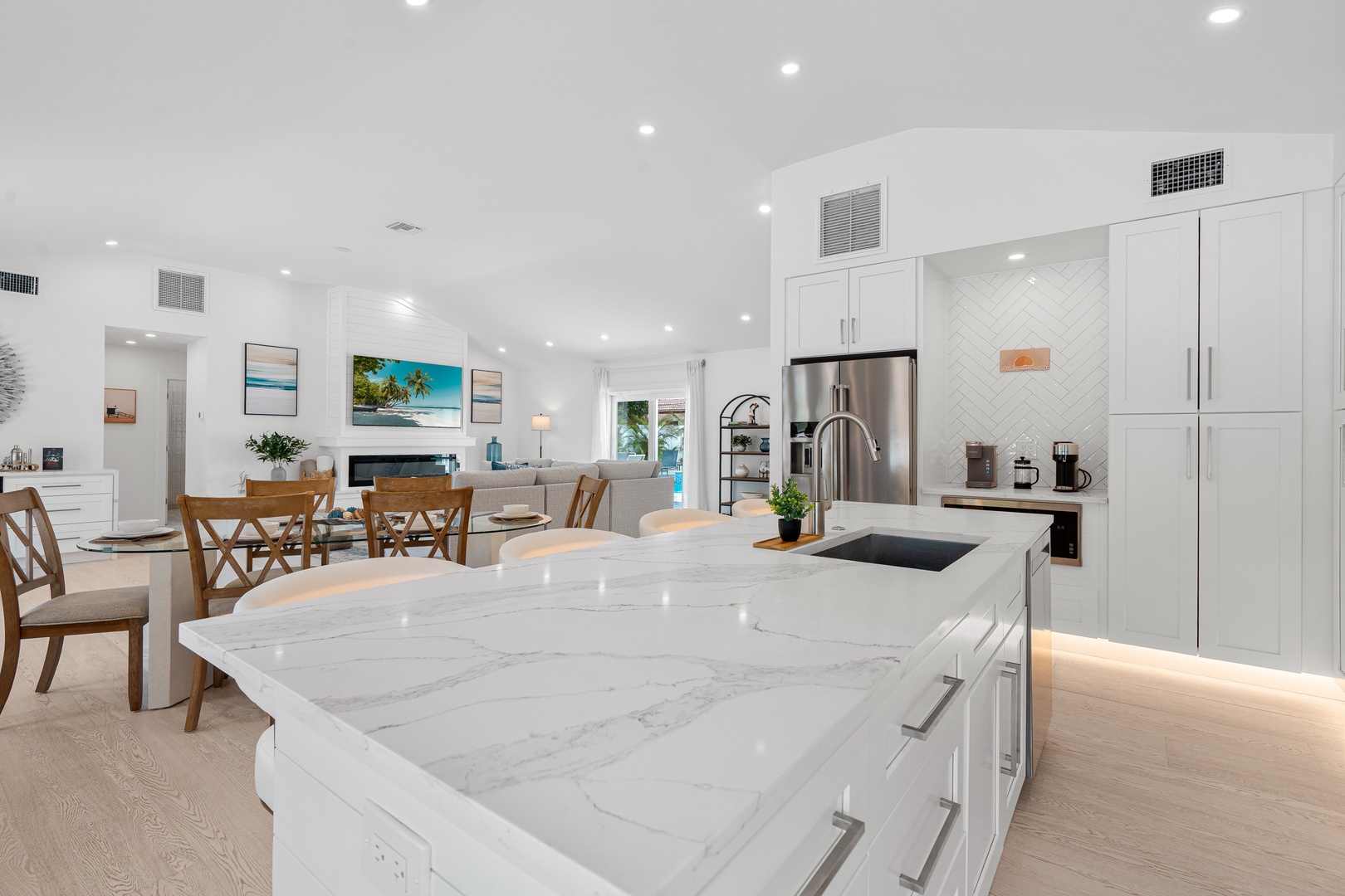 Step into your open-concept haven, where a luminous kitchen with marble countertops flows seamlessly into a sunlit living and dining space, inviting you to cook, gather, and relax in effortless style.