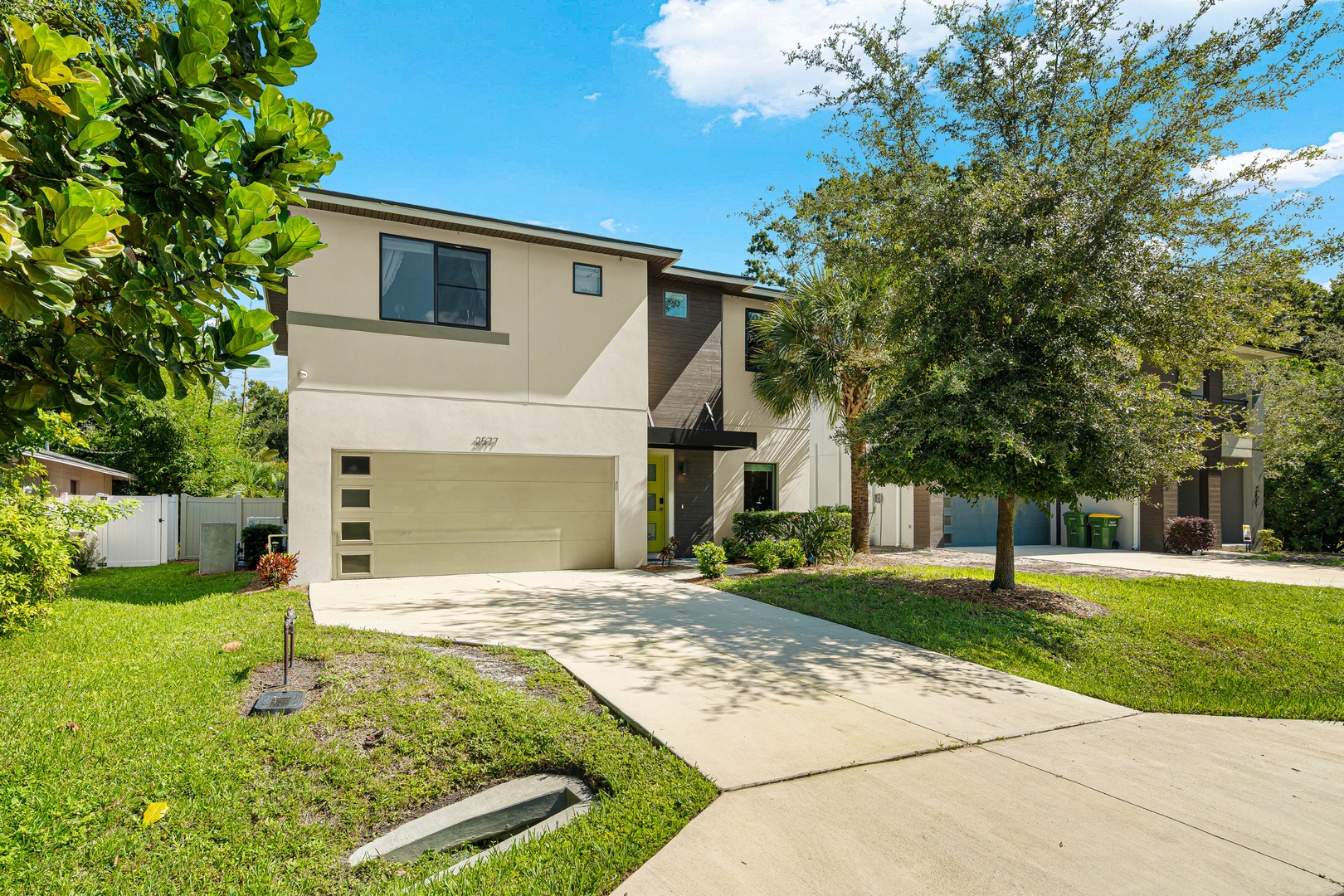 A contemporary two-story home set in a quiet, tree-lined neighborhood. The modern facade, spacious driveway, and lush greenery welcome you to this peaceful Florida retreat.
