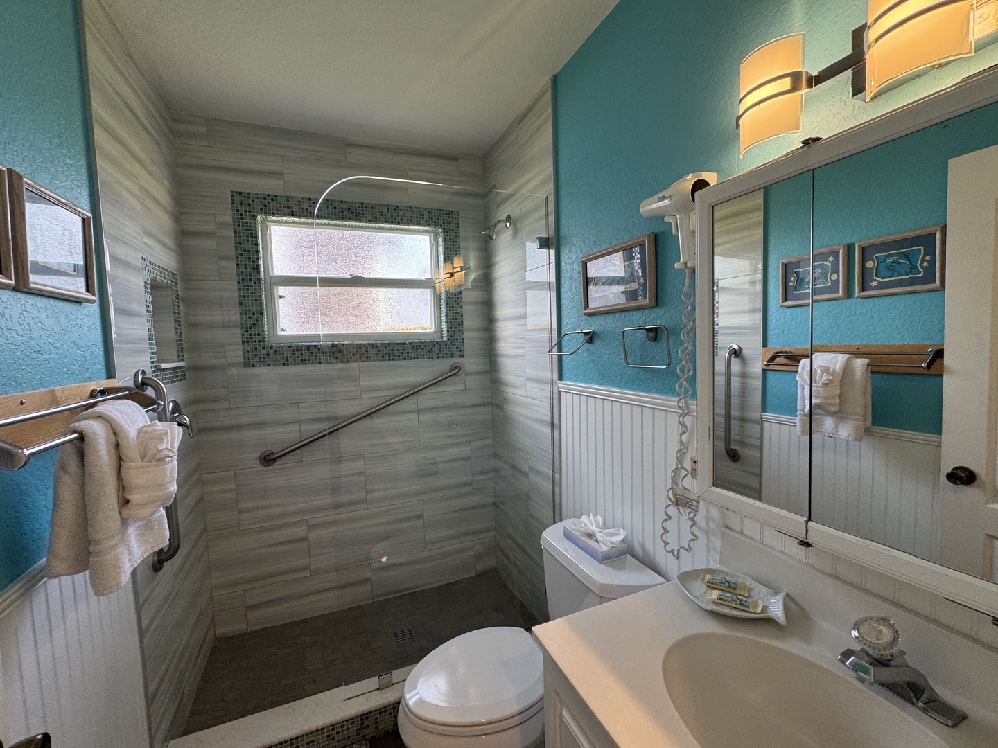 Step into your beautifully tiled bathroom with a spacious walk-in shower, fresh towels waiting, and calming coastal touches that make you feel right at home.