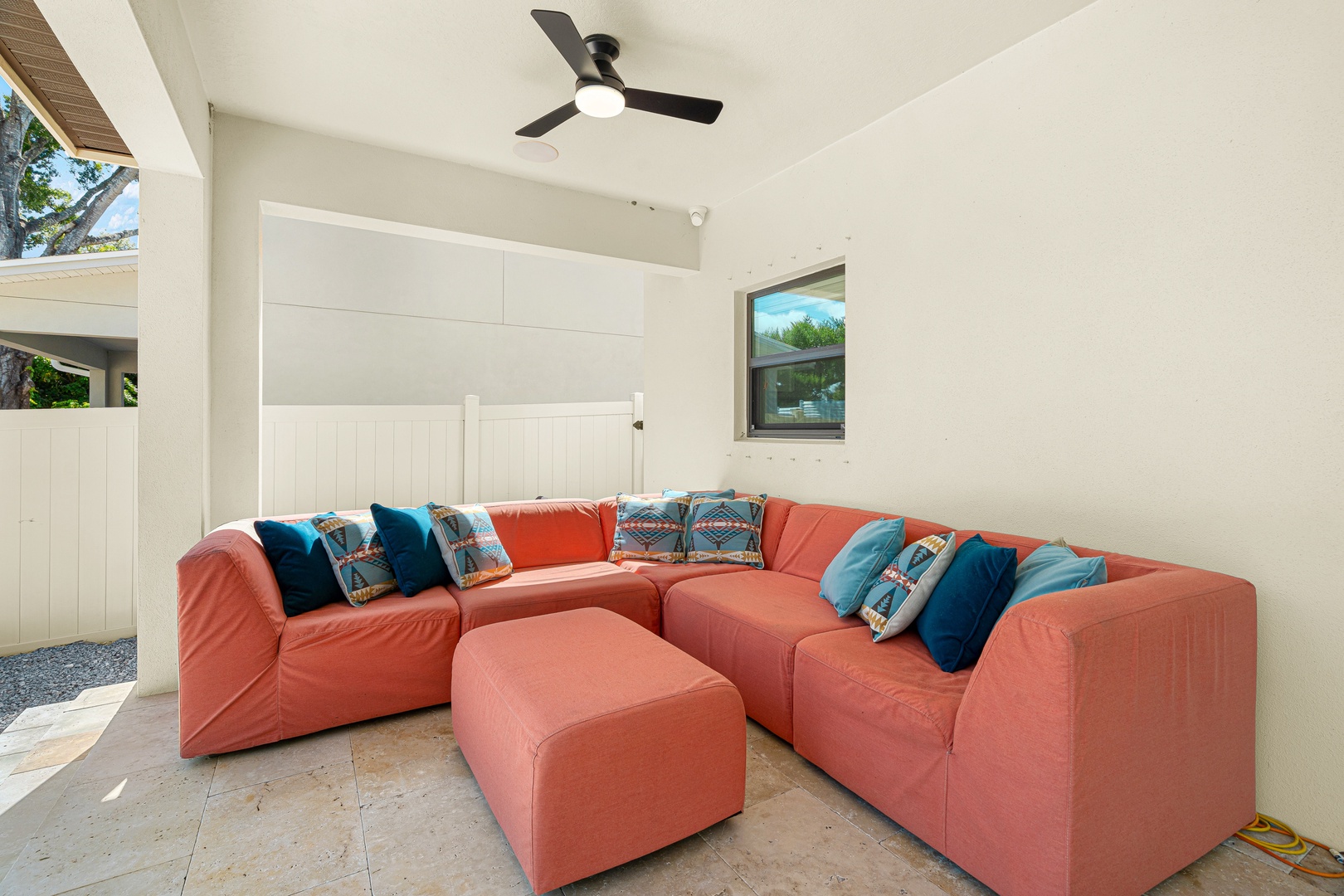 Sink into plush coral cushions and feel the ceiling fan's gentle breeze as you unwind in your private outdoor living space—perfect for lazy afternoons and starlit conversations.