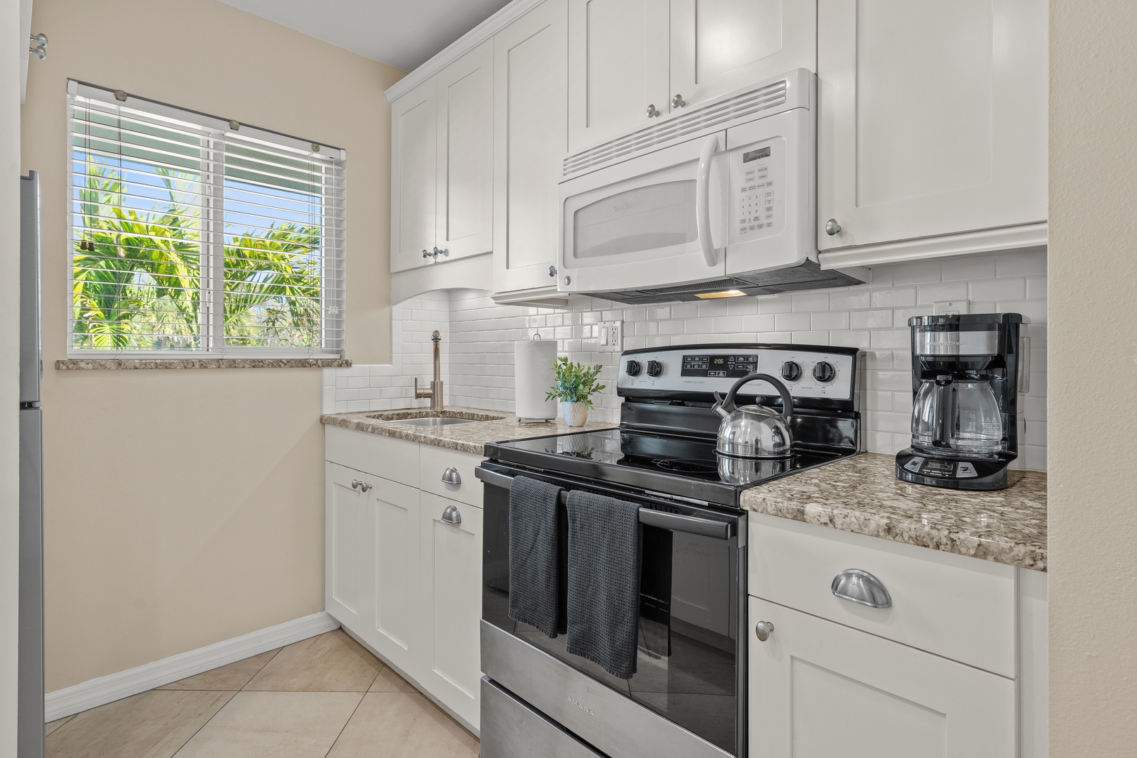 Your bright, fully equipped kitchen awaits with granite counters, modern appliances, and tropical views to inspire your culinary adventures.