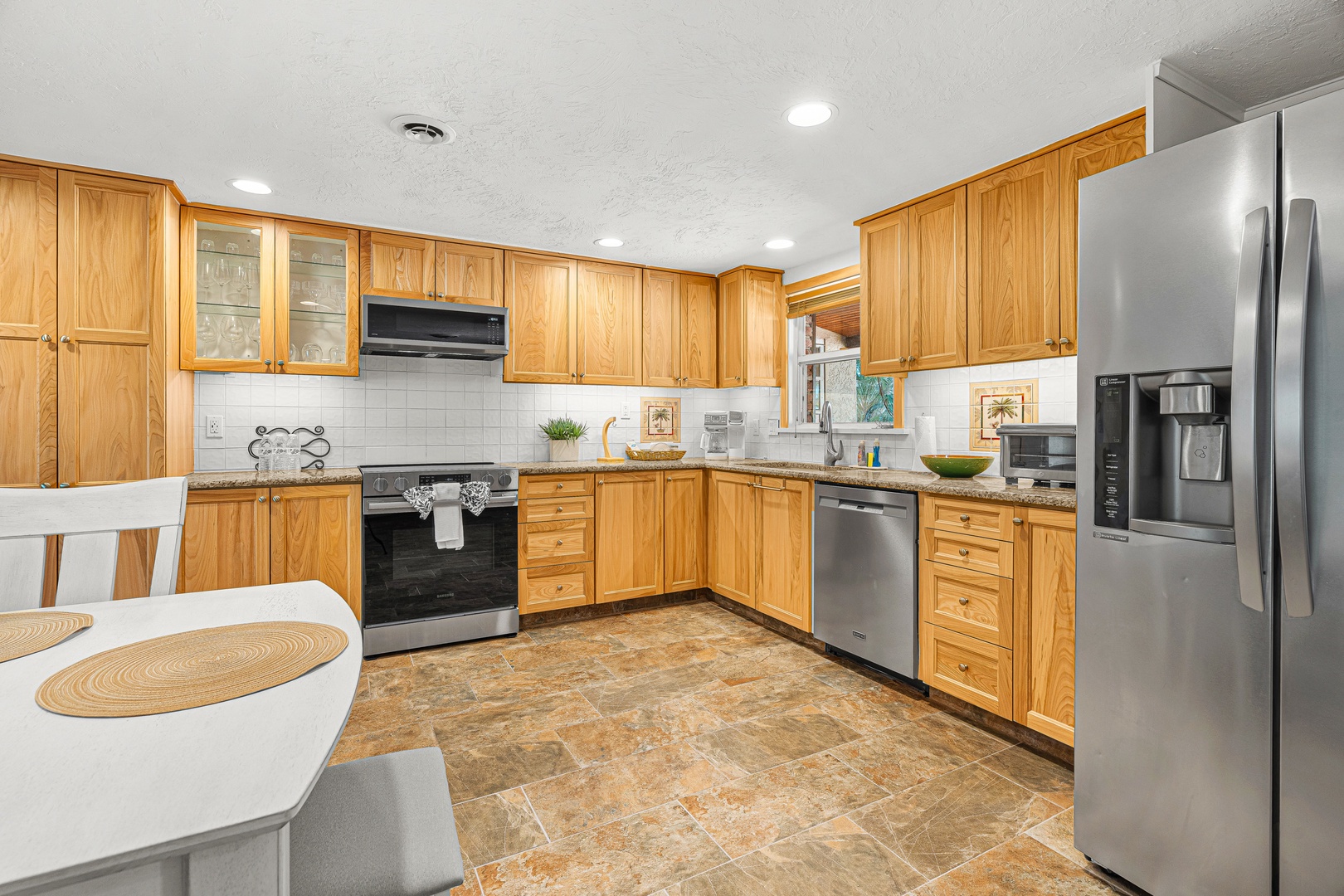 Your fully equipped kitchen awaits with warm wood cabinetry, stainless steel appliances, and granite countertops—perfect for preparing home-cooked meals during your stay.