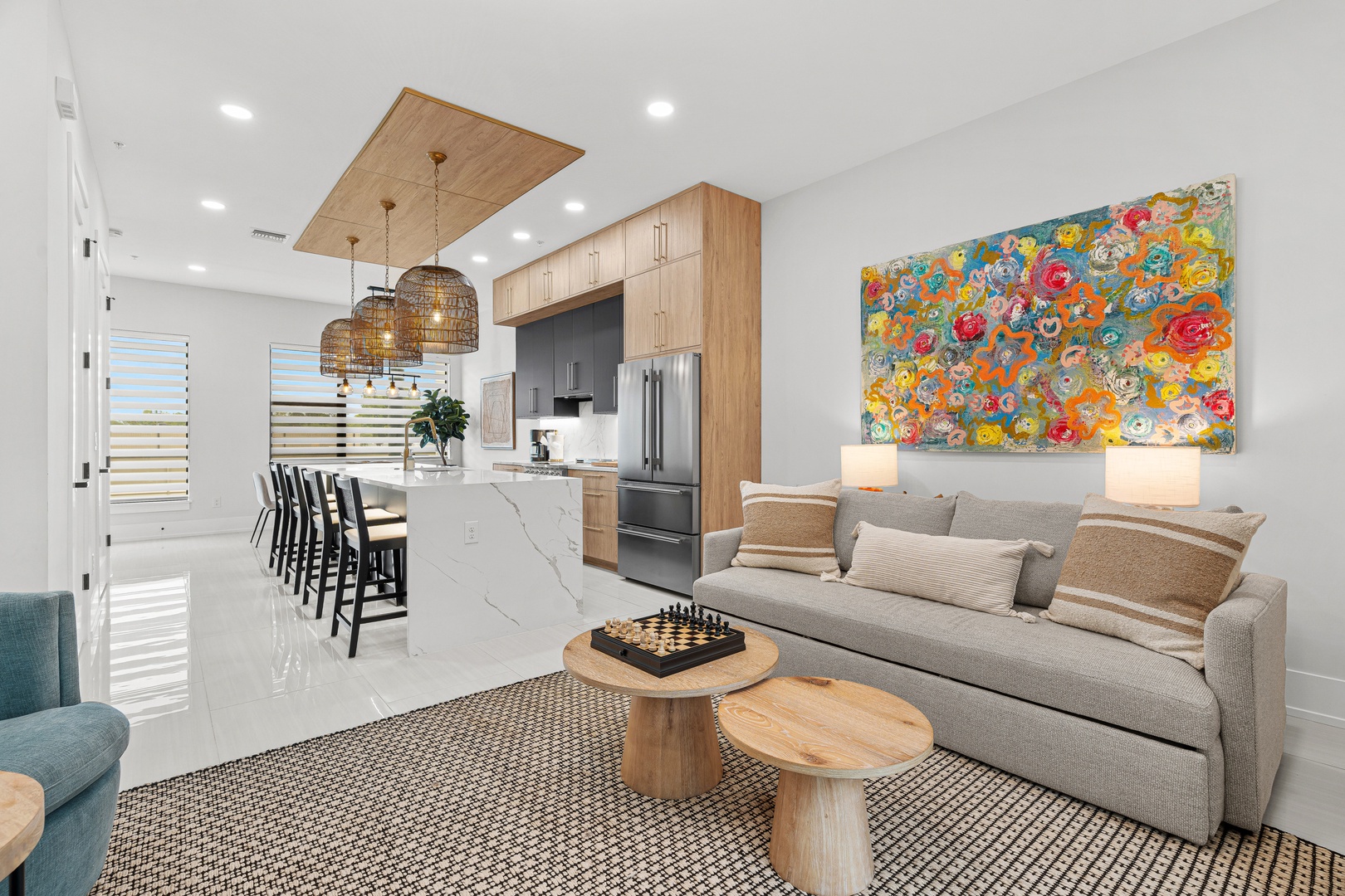 Settle into your bright open-plan living area, where sleek design meets coastal comfort. Cook in a modern kitchen with gleaming countertops, unwind on the sofa, and enjoy vibrant artwork that makes the space feel like home.