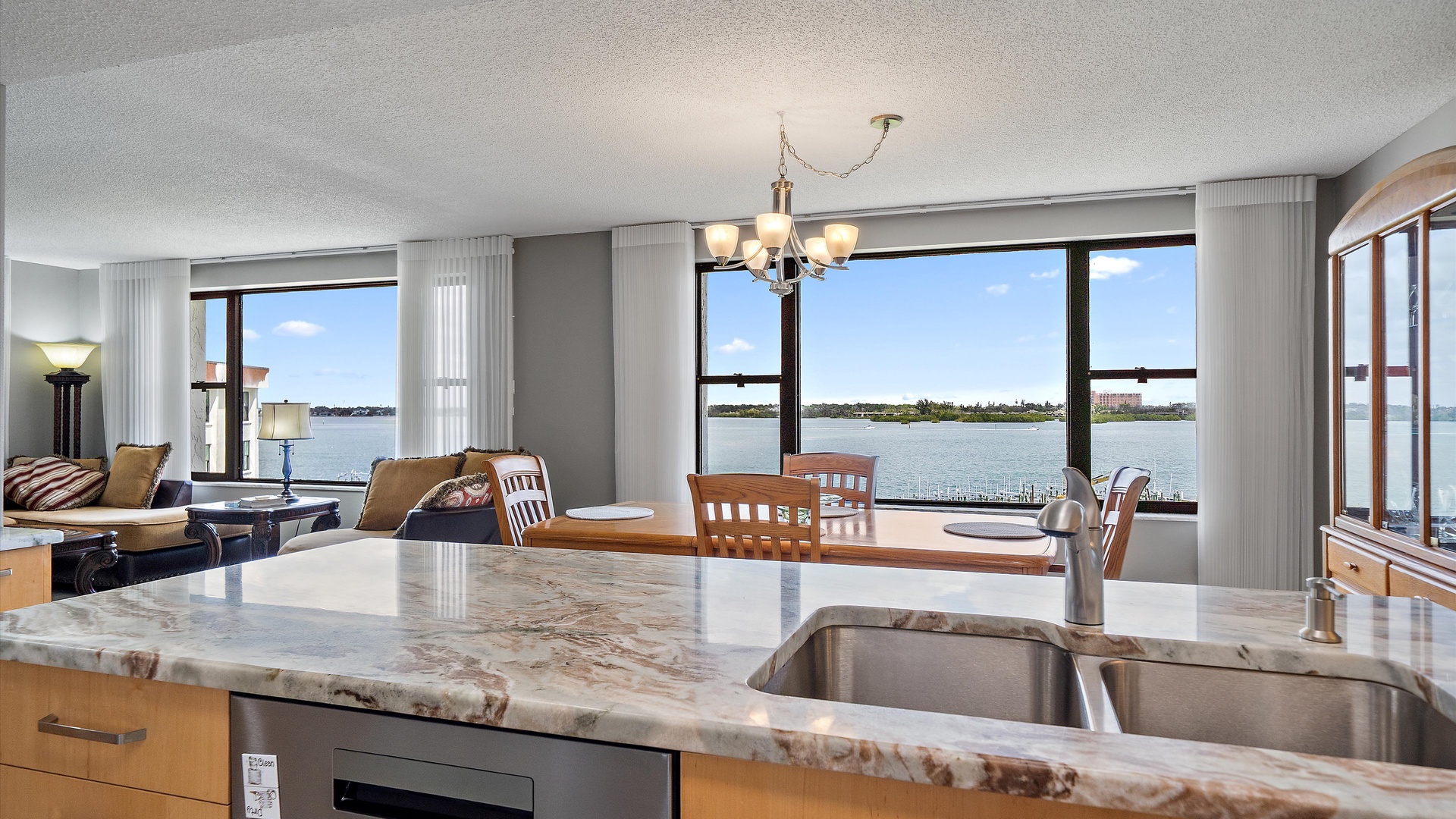 Your kitchen flows seamlessly into the dining area, where stunning lake views frame every meal through floor-to-ceiling windows.