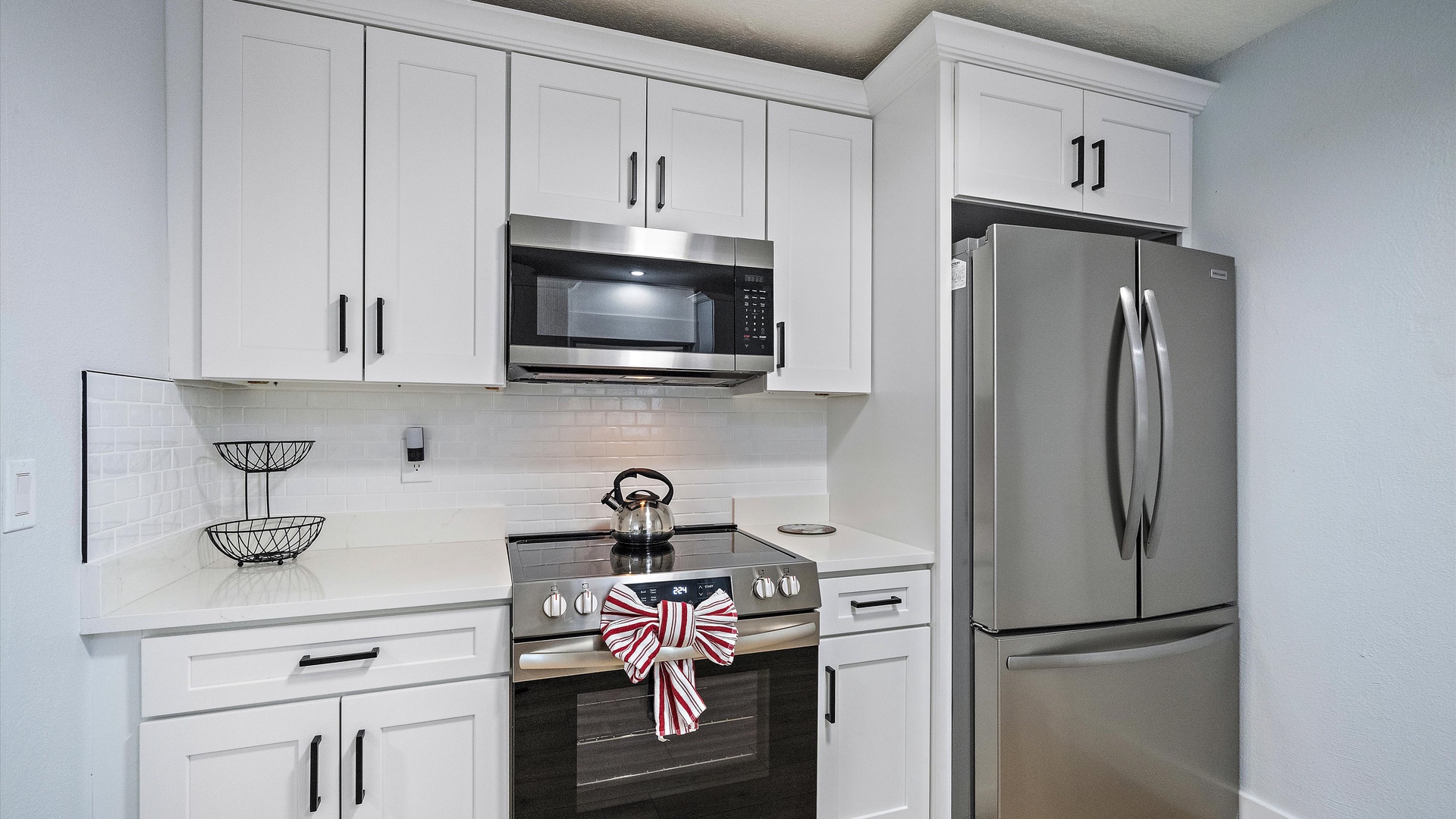 Step into a bright, fully-equipped kitchen with stainless steel appliances and plenty of counter space for preparing your favorite meals during your stay.