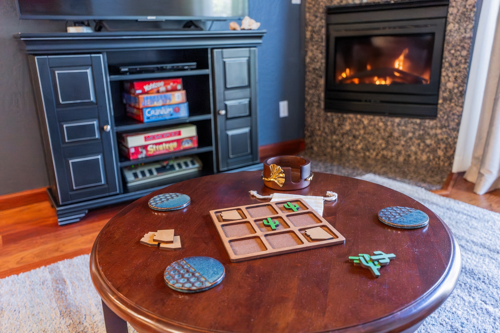Cozy up by the crackling fireplace with board games ready for your perfect evening in this inviting living space.