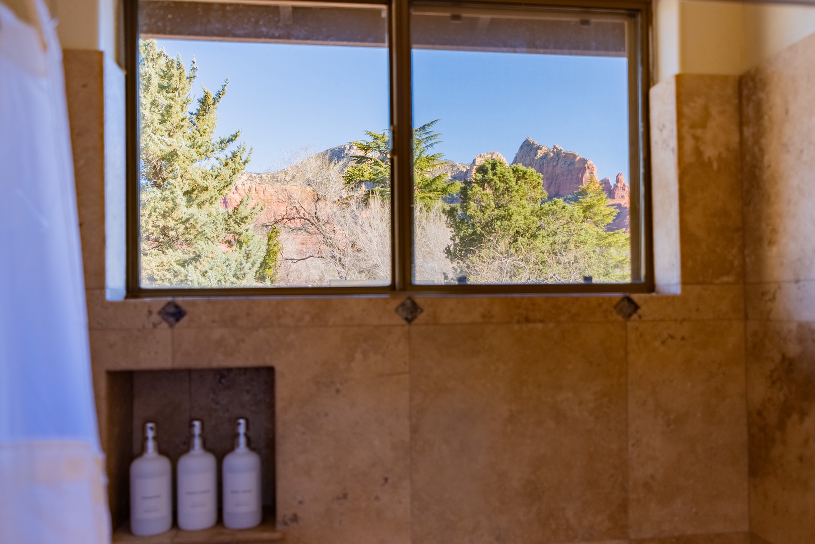 Soak in breathtaking red rock mountain views while you unwind in your private shower, where premium amenities meet nature's grandeur.