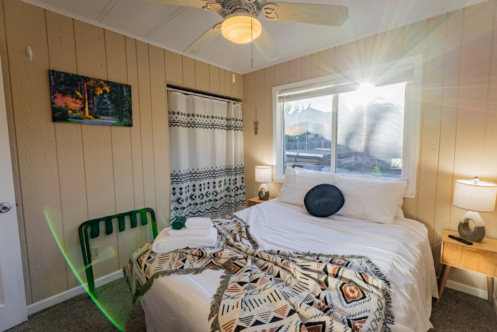 Relax in your cozy bedroom with warm wood paneling, crisp white linens, and patterned textiles that create a welcoming retreat after your adventures.