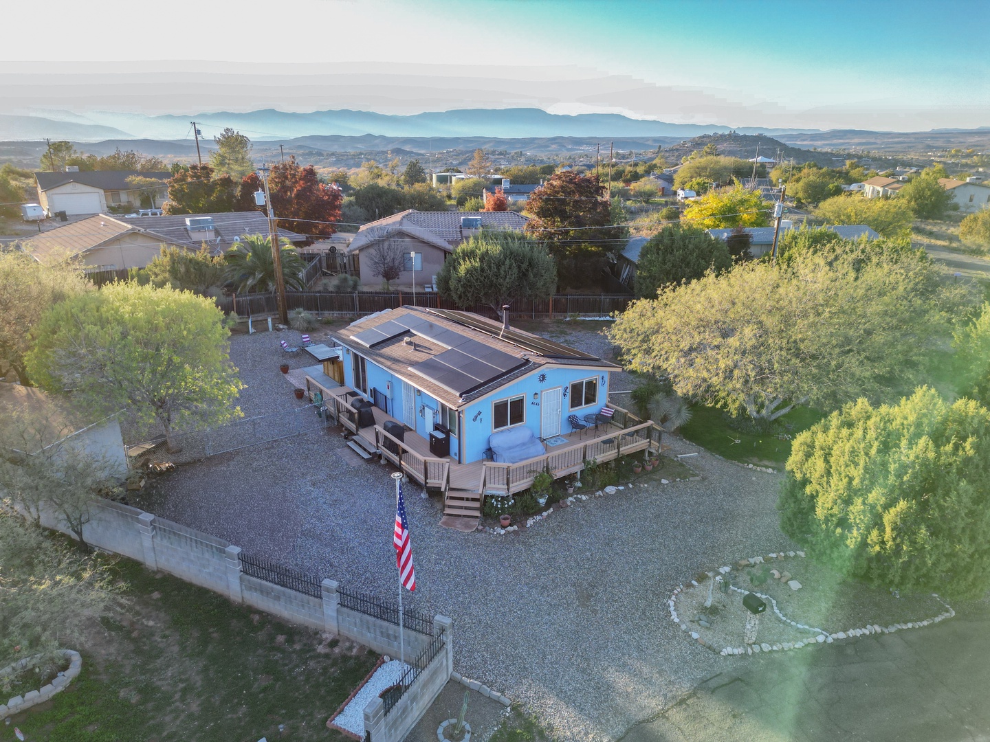 Aerial view of the property nestled in a scenic residential neighborhood with mountain vistas in the distance.