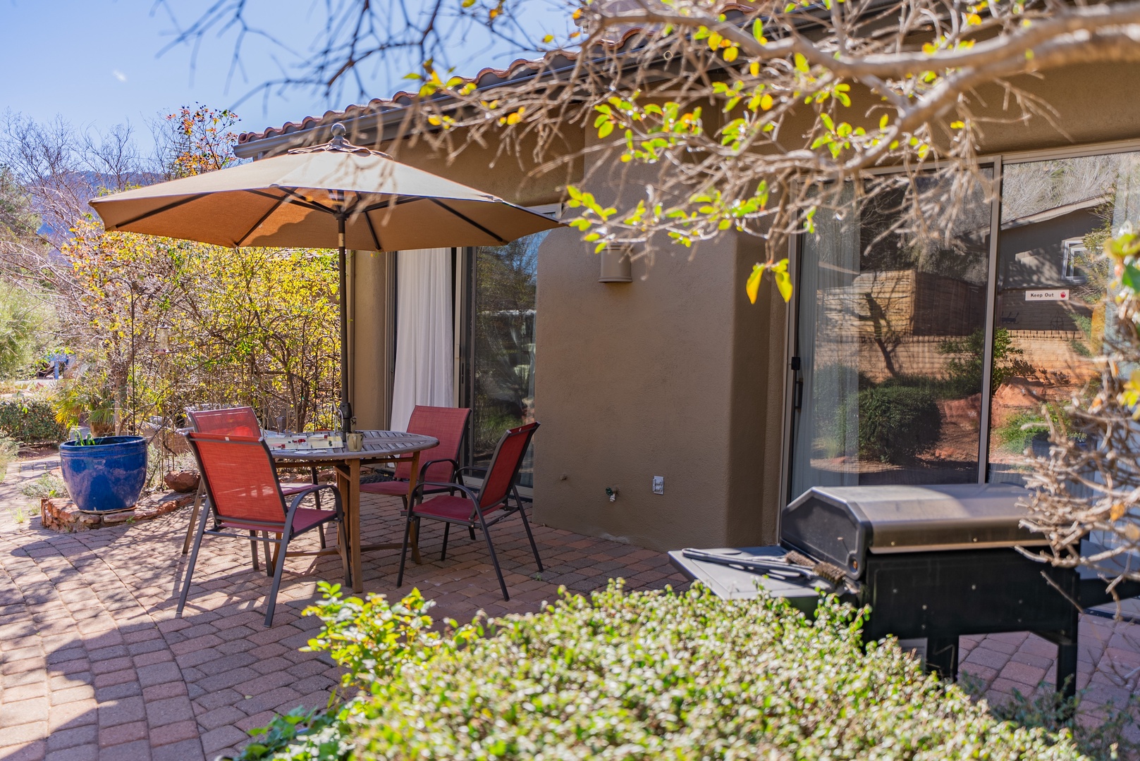Step onto your private patio with comfortable seating, BBQ grill, and umbrella shade - perfect for outdoor dining and relaxation.