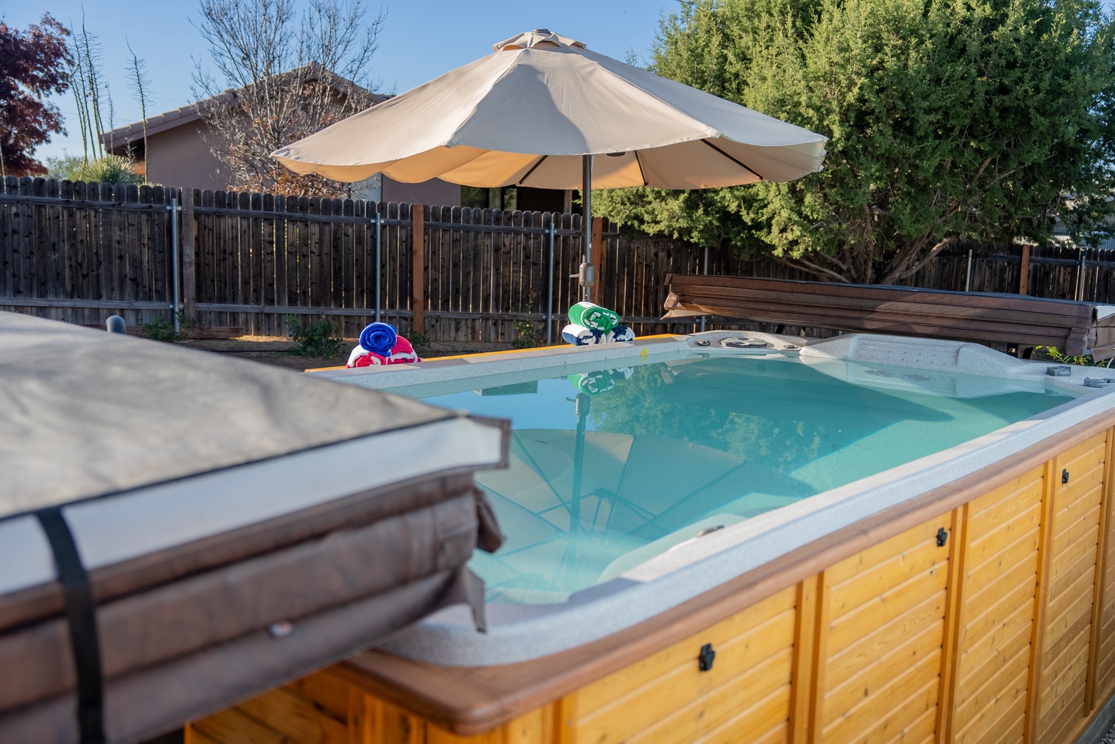 Soak in your private hot tub surrounded by comfortable lounge chairs and shade, perfect for relaxing after a day of exploring.