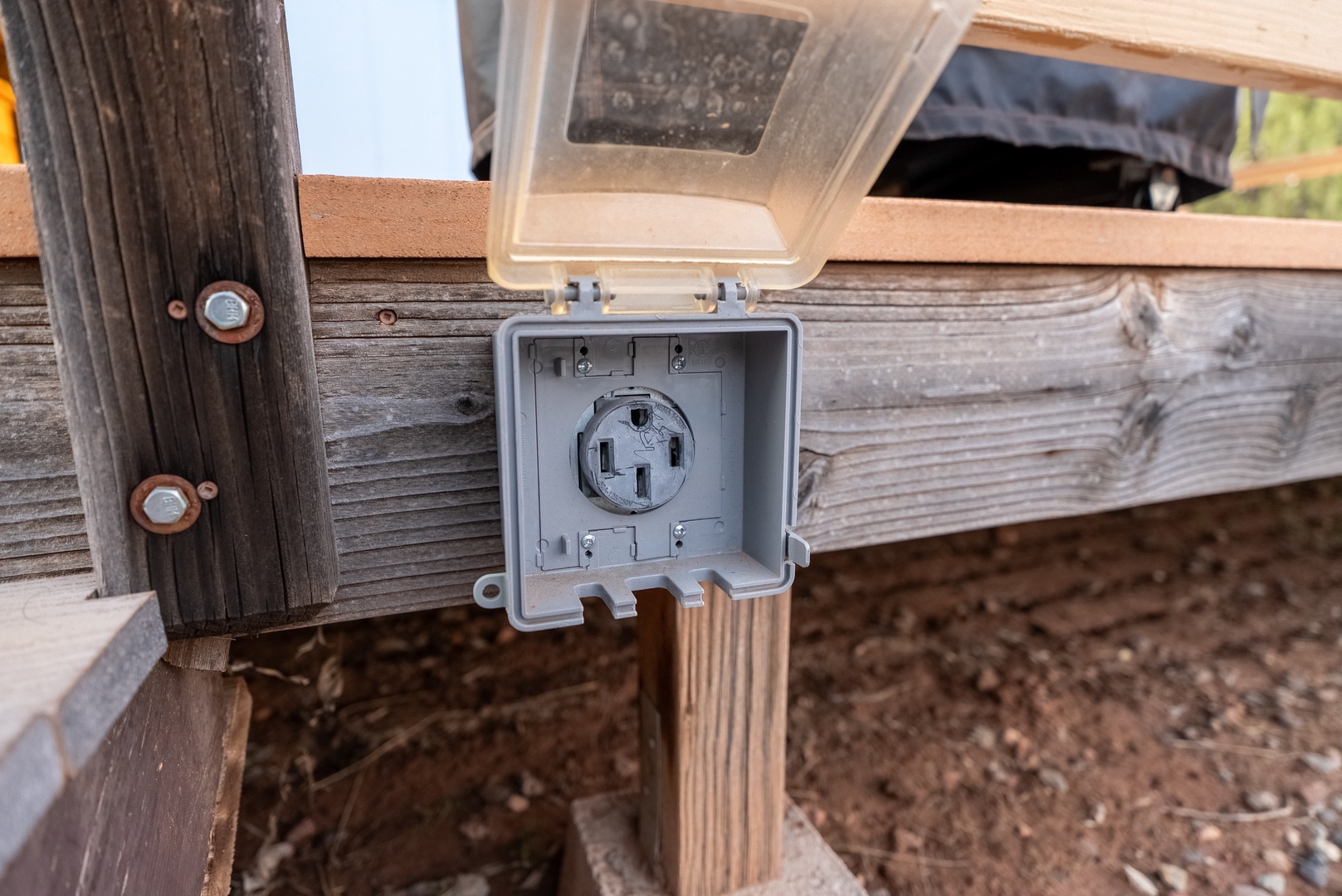 Convenient outdoor electrical outlet with weatherproof cover on the deck for your devices and equipment.