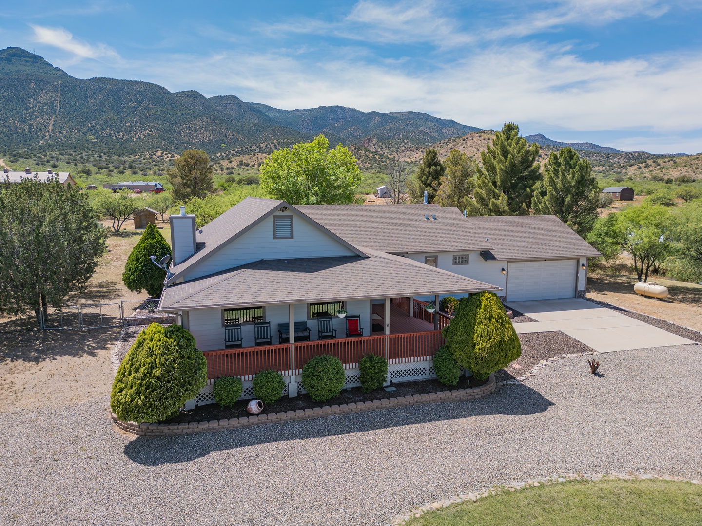 Aerial view of a spacious mountain retreat nestled against dramatic desert peaks with surrounding natural landscape.
