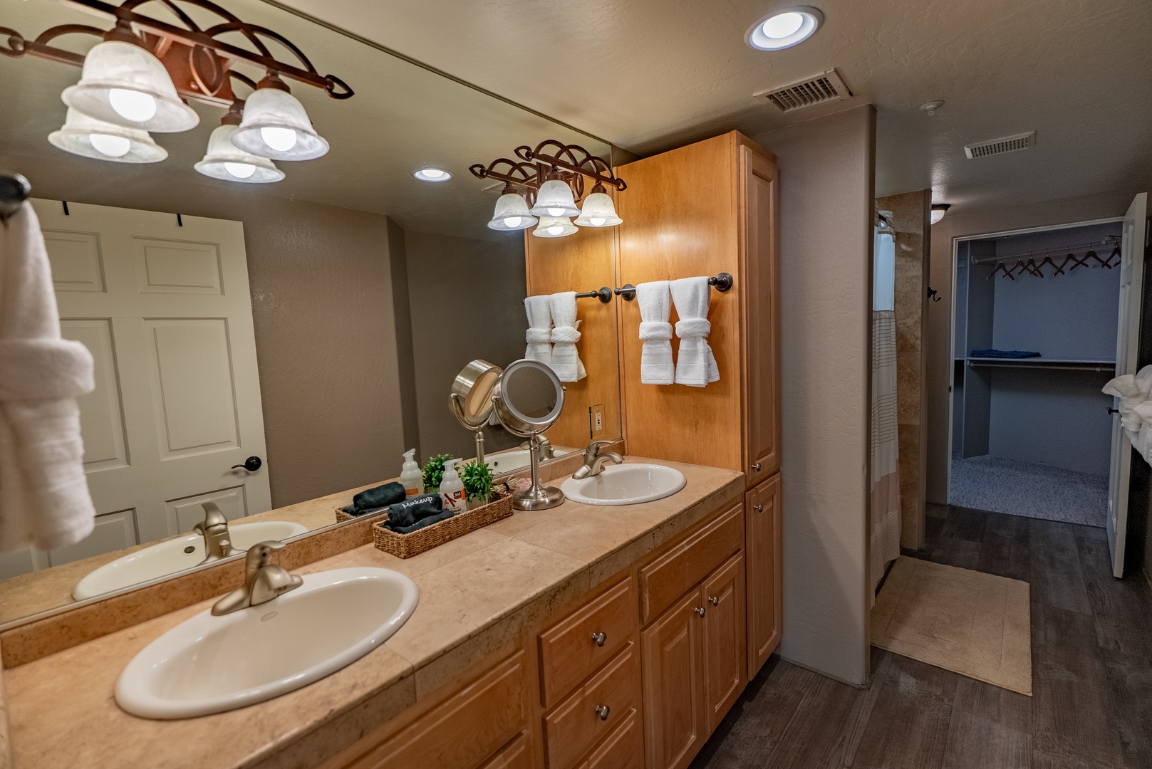 Prepare for your day in this spacious master bathroom featuring dual vanities, elegant lighting, and thoughtful amenities for your comfort.