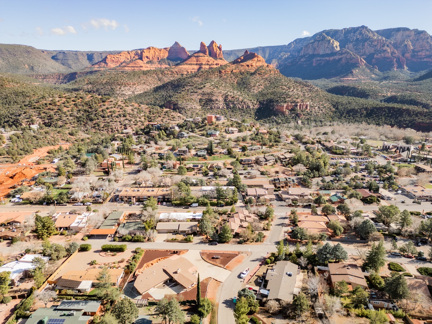 Aerial view of Sedona showcasing the dramatic red rock formations and residential community nestled in Arizona's stunning desert landscape.