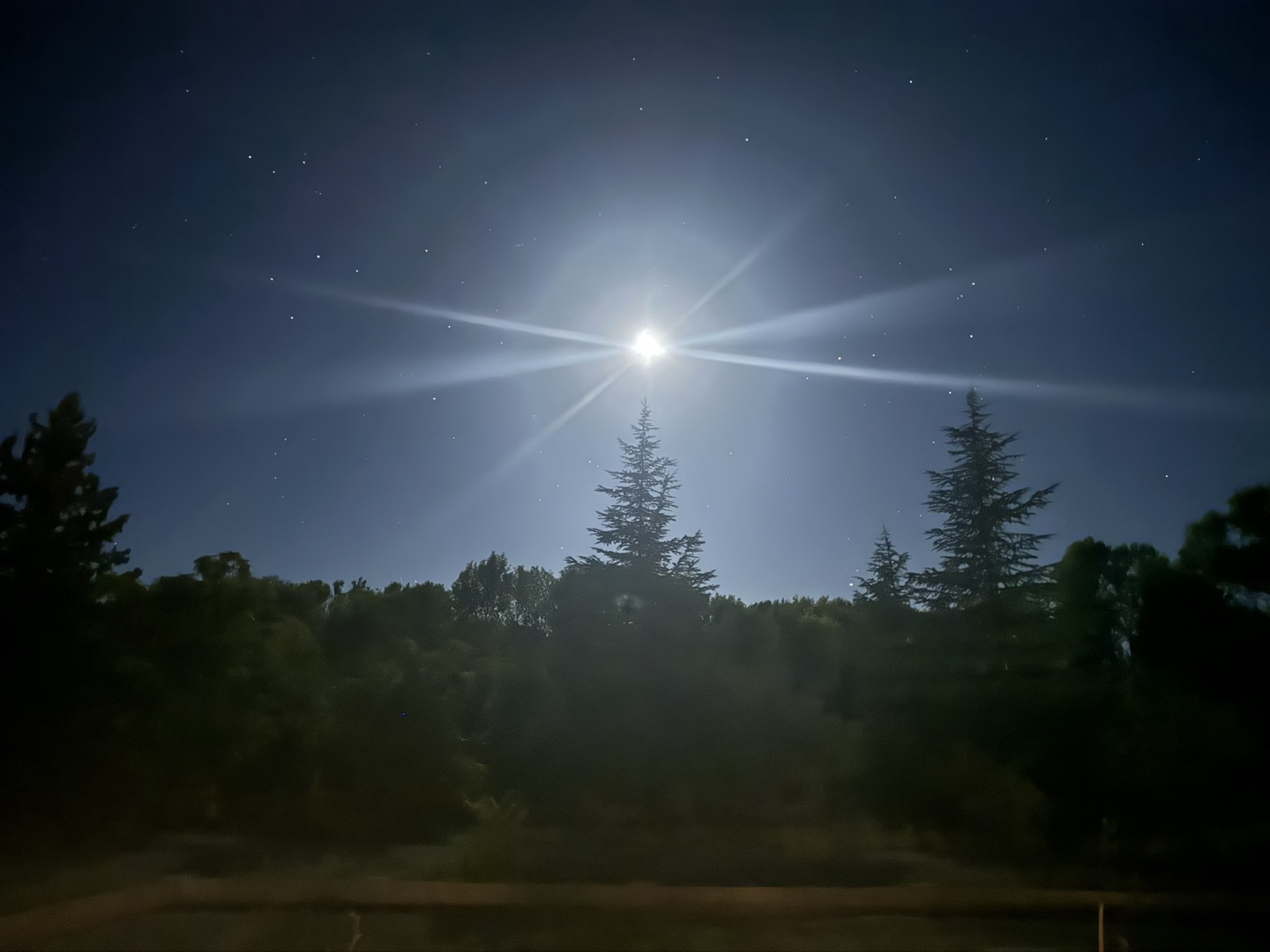 A stunning moonbow radiates through the night sky above.                         surrounded by stars and natural beauty in the peaceful countryside near the property.