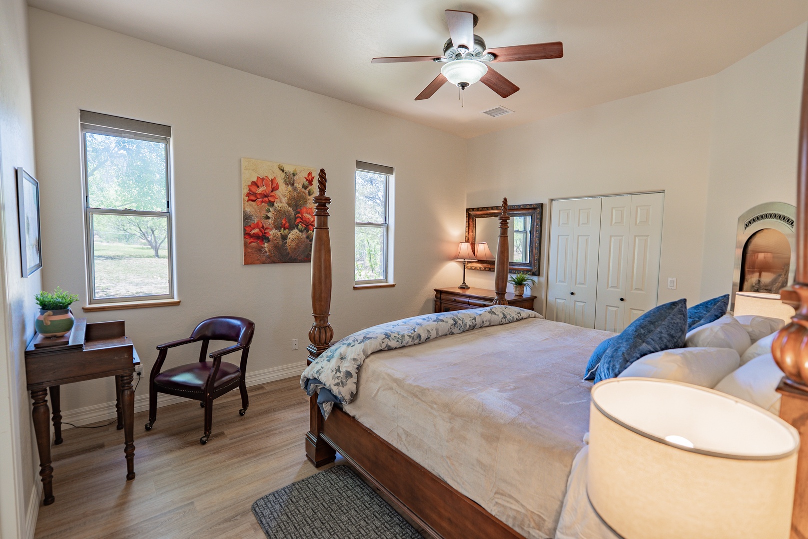 Unwind in your elegant bedroom with classic four-poster bed, peaceful garden views, and cozy workspace—your perfect retreat.