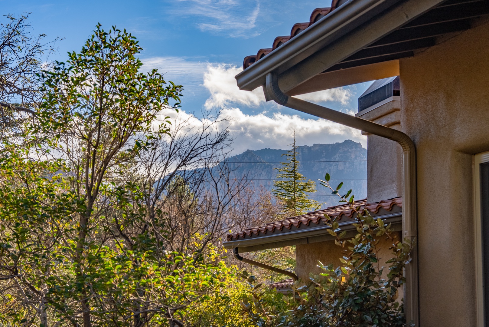 Mountain views frame this peaceful property, surrounded by lush gardens and scenic natural landscape in a tranquil setting.