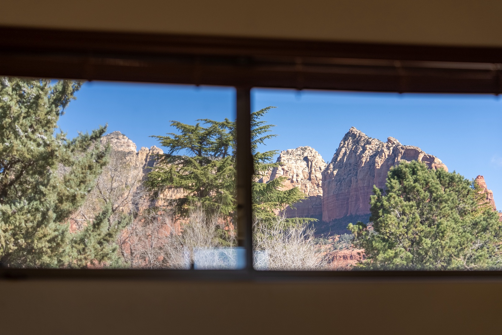 Wake up to stunning red rock formations framed perfectly through your bedroom window—nature's masterpiece greets you each morning.