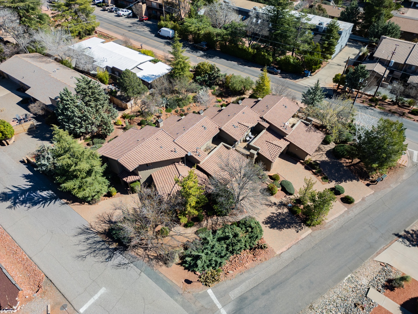 Aerial view of the property showcasing its distinctive architecture and beautifully landscaped grounds in a peaceful residential setting.
