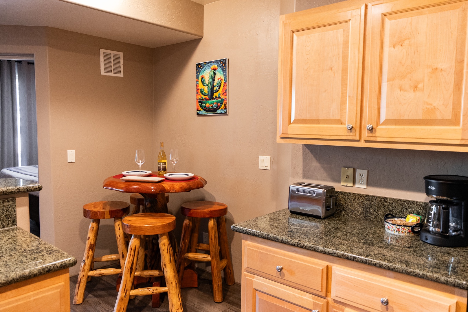 Your cozy kitchen corner features rustic wood dining with granite counters and coffee maker for perfect morning starts.