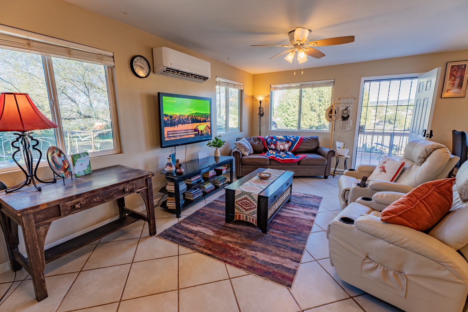 Unwind in your spacious living room with comfortable seating, large TV, and ceiling fan for ultimate relaxation after exploring the area.