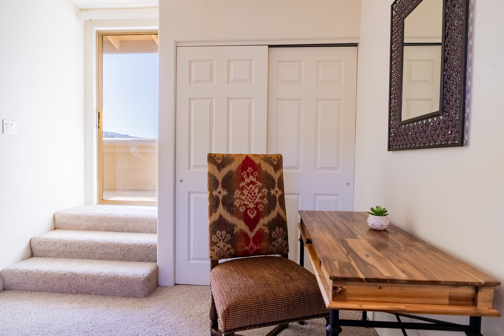 Your cozy workspace features a handcrafted wooden desk and ornate patterned chair, creating the perfect spot to plan adventures.