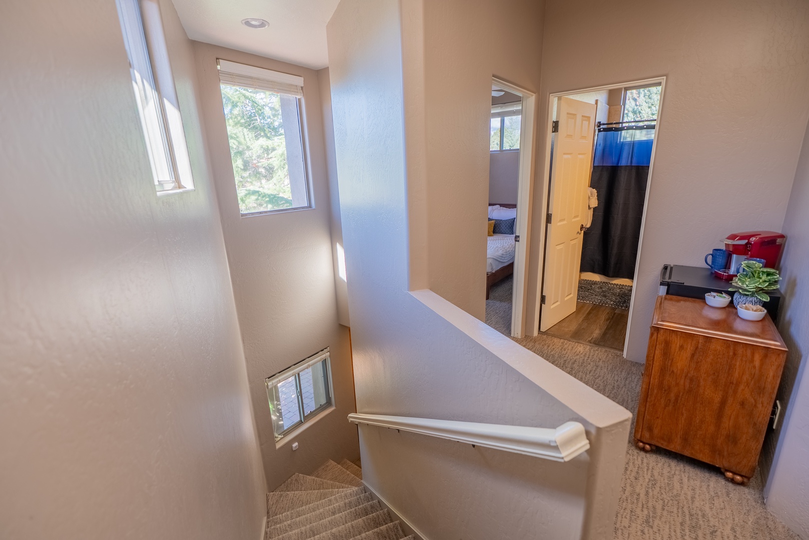 Natural light fills your cozy upstairs hallway, connecting bedrooms and bathroom with warm wood touches throughout.
