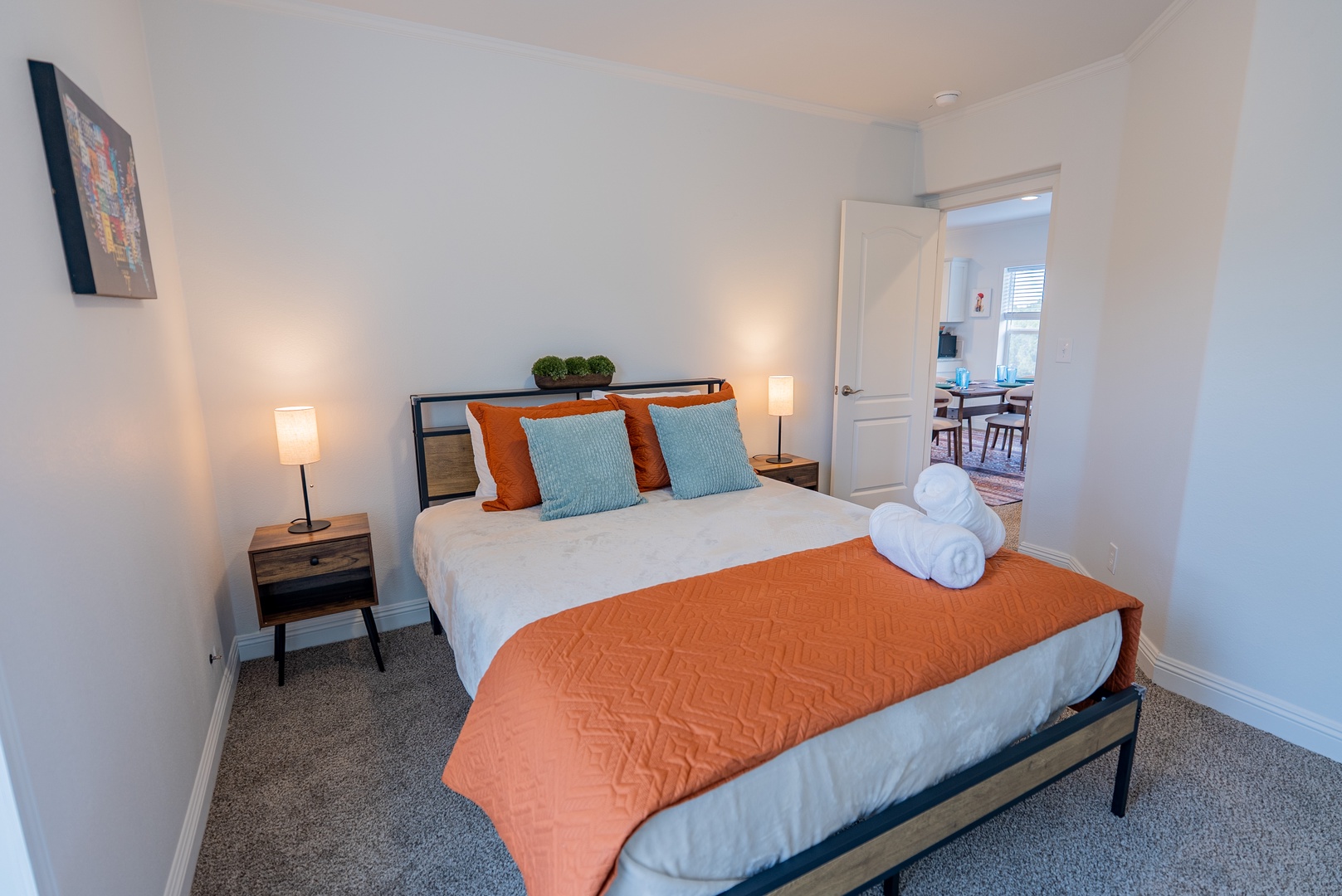 Bedroom features comfy Queen bed close to bathroom