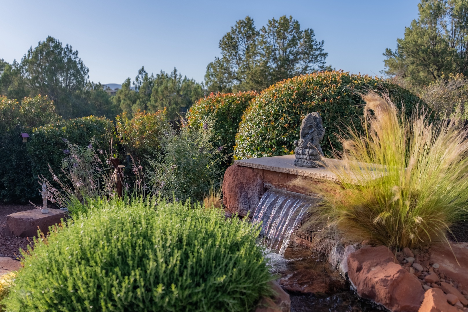 Lush landscaped garden features a peaceful water fountain
