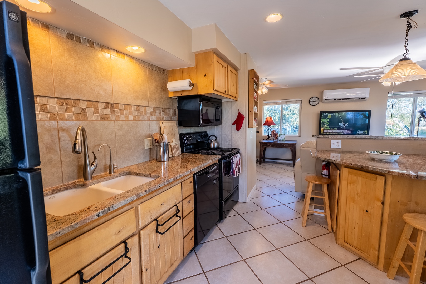 Your fully equipped kitchen features granite countertops, modern appliances, and a breakfast bar where you can prepare meals and enjoy casual dining with natural light streaming in.