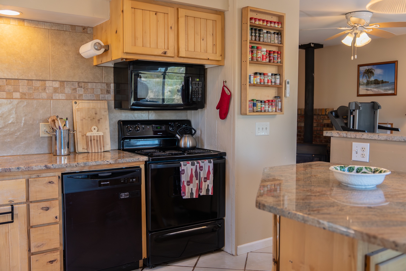 Your fully equipped kitchen features granite countertops, black appliances, and plenty of cabinet space, with a well-stocked spice rack for all your culinary adventures.