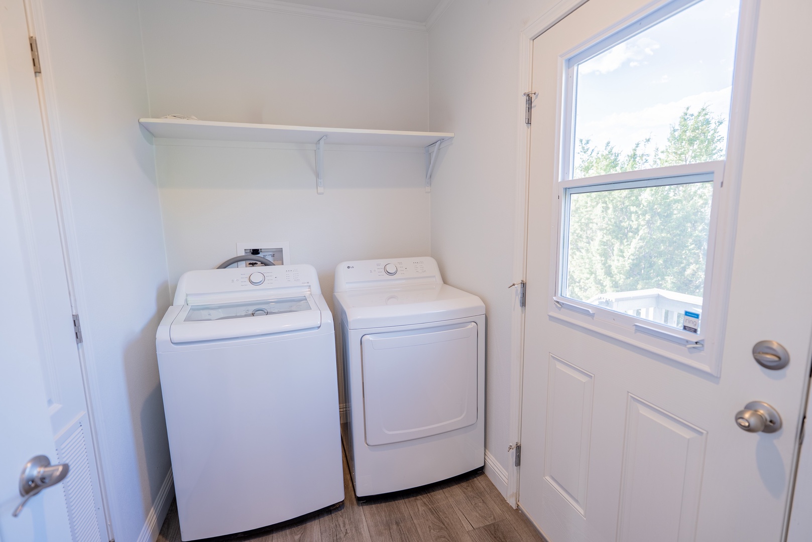 Full-size washer and dryer, and door to backyard. .
