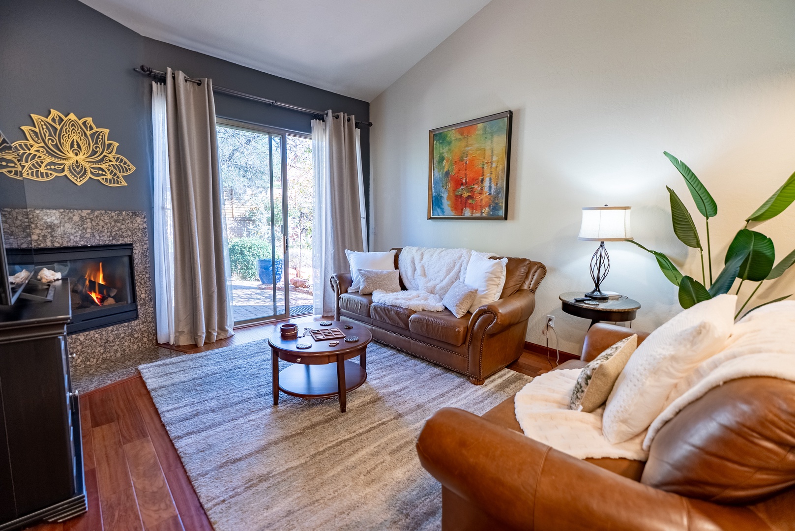 Sink into plush leather seating while the crackling fireplace warms your evening retreat in this thoughtfully designed living space.