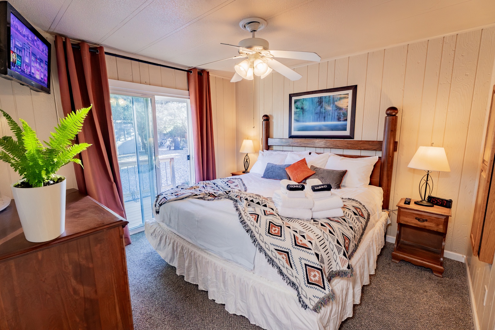 Unwind in your cozy bedroom featuring comfortable bedding, bedside amenities, and a sliding door to your private outdoor space.