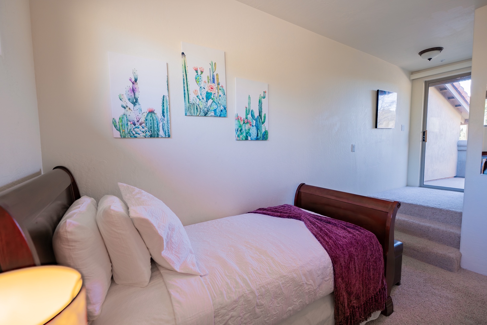 Sink into crisp linens and let the cheerful cactus artwork brighten your mornings in this peaceful bedroom retreat.