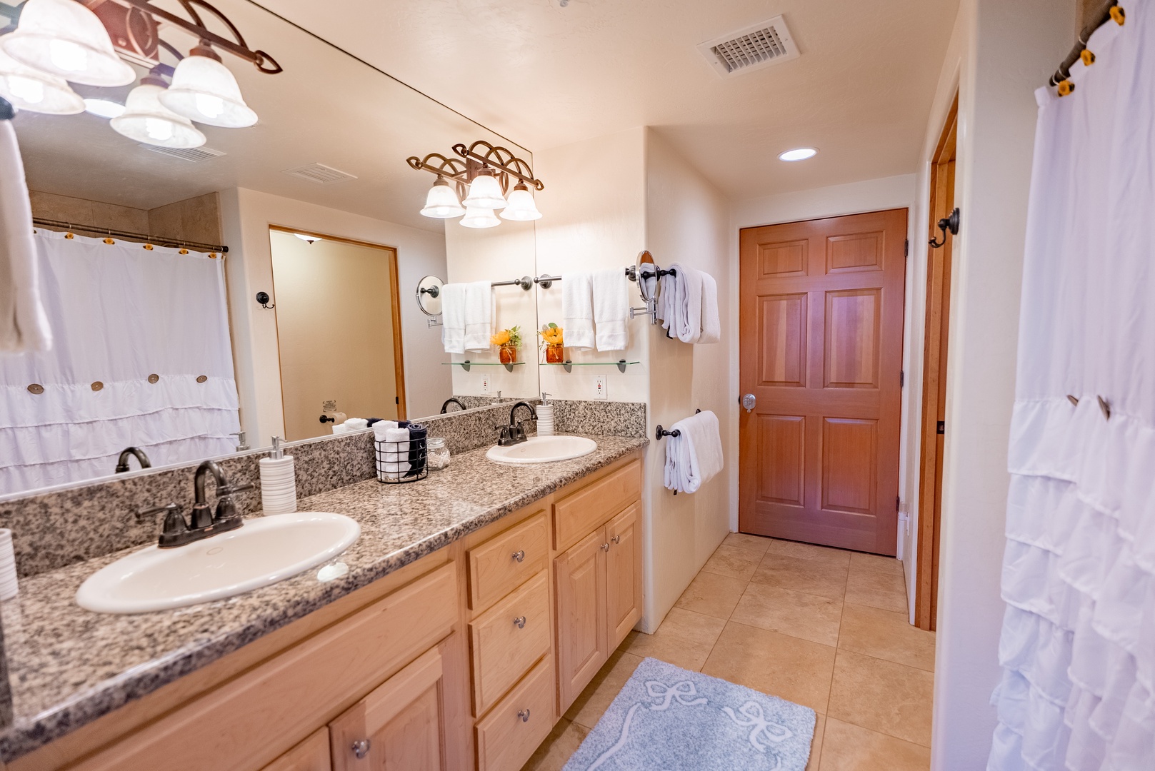 Unwind in your spacious bathroom featuring dual vanities, granite countertops, and plush robes waiting for your arrival.