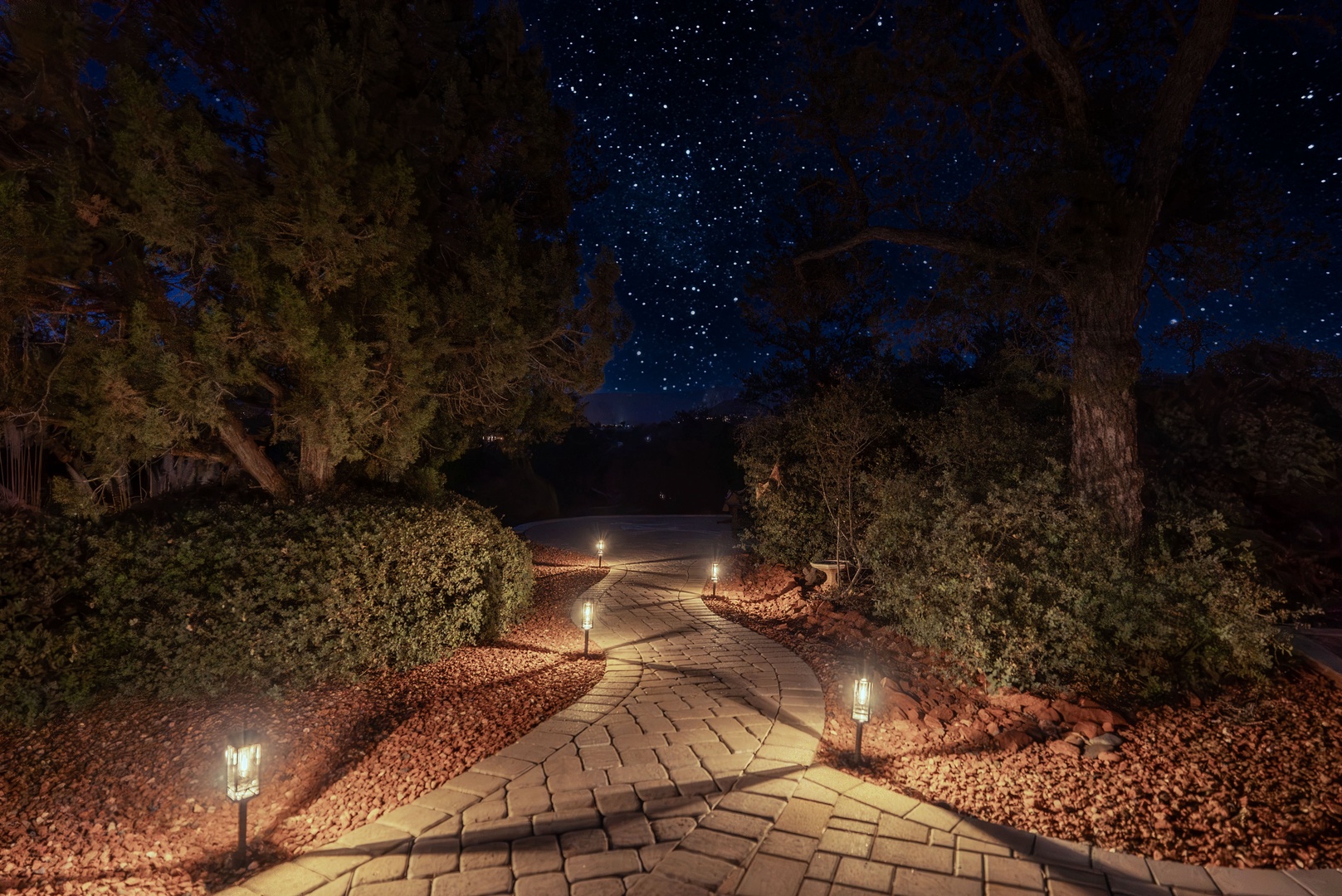 A beautifully lit stone pathway winds to the dark sky meditation and viewing patio