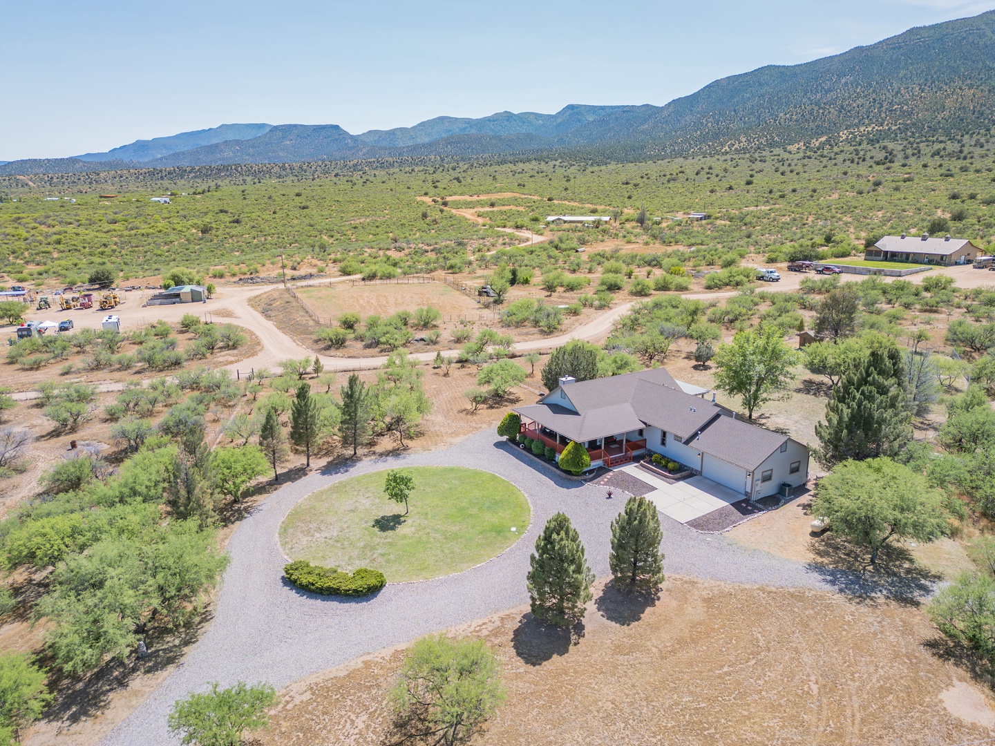 Stunning aerial perspective of the property nestled in pristine high desert landscape, surrounded by rolling hills and natural vegetation.
