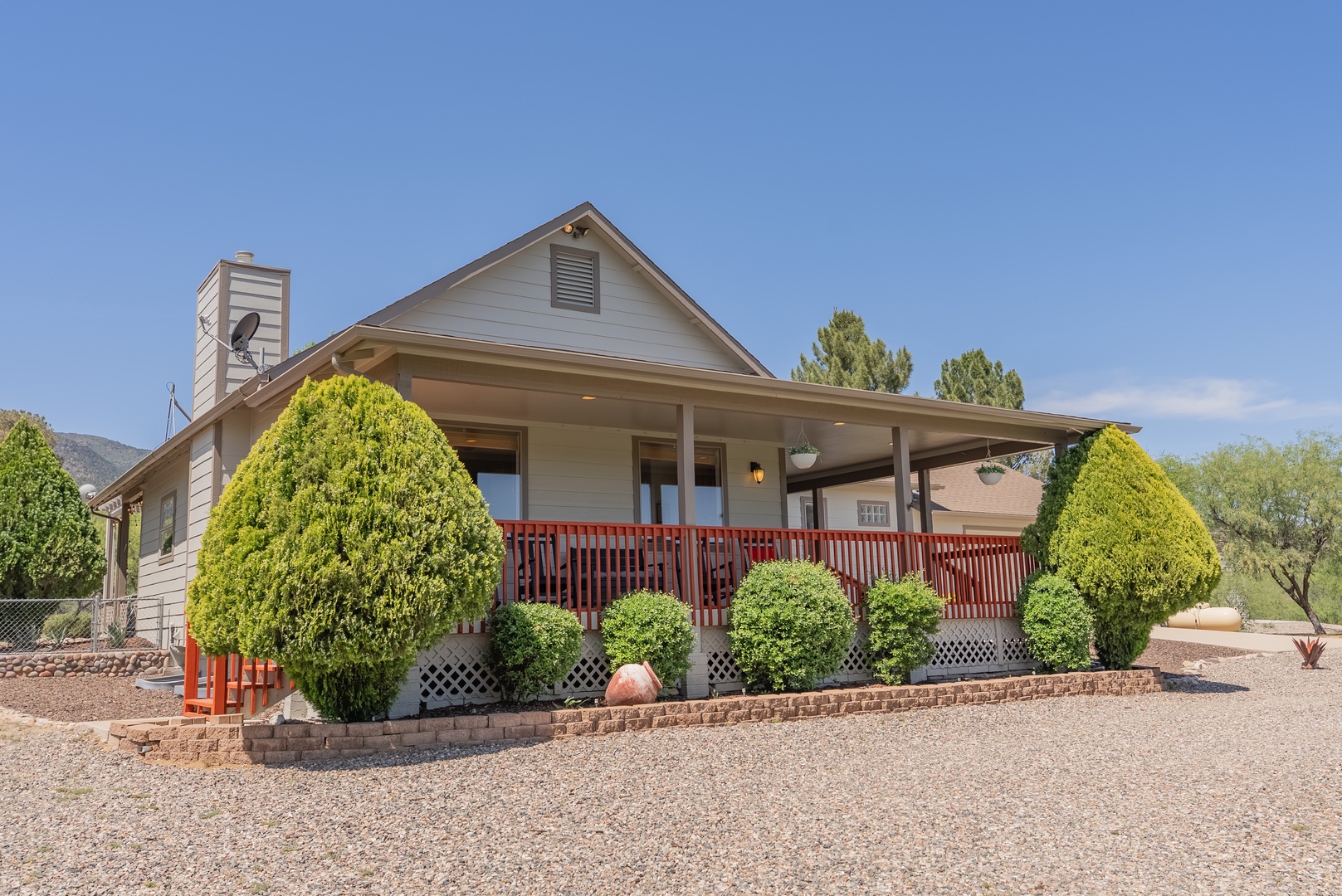 Charming single-story home with welcoming covered porch and mature landscaping in a peaceful desert setting.