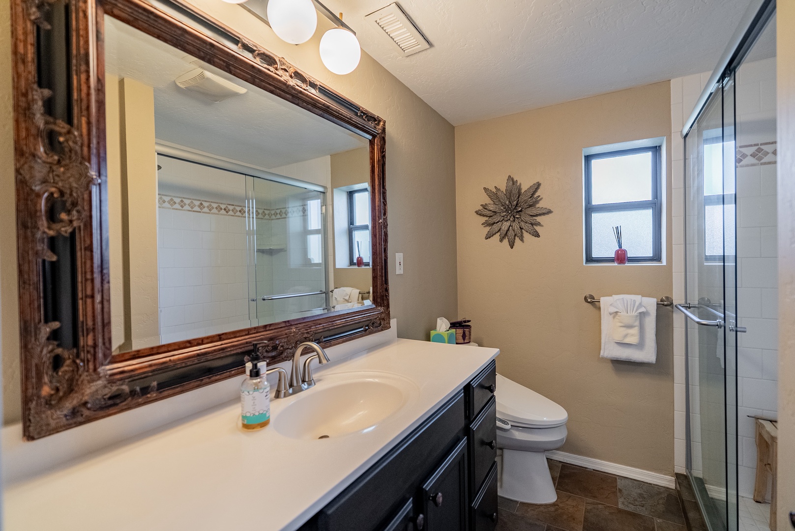 Step into your serene private bathroom, where soft lighting and tasteful decor create a peaceful retreat. Freshen up at the elegant vanity, then unwind in the walk-in shower, all within your comfortable home away from home.