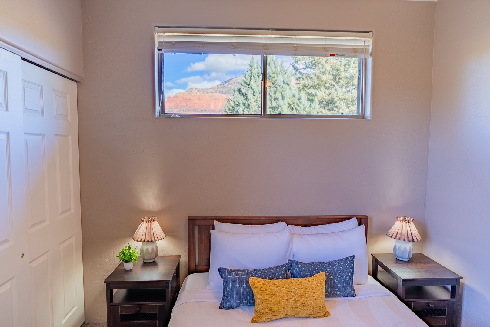 Wake up to natural light streaming through your window, showcasing mountain views and lush trees from your cozy bedroom.