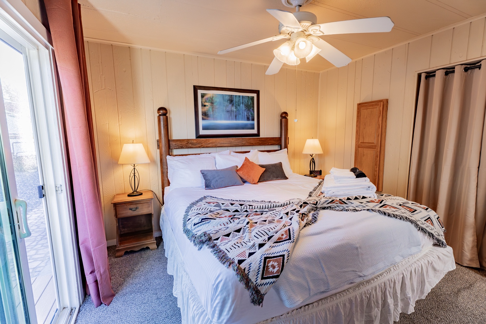Relax in your cozy bedroom featuring a comfortable King bed, warm wood paneling, and soft lighting that creates the perfect atmosphere for a peaceful night's rest.