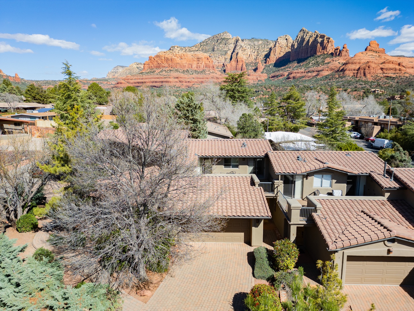 Stunning red rock formations dominate the landscape, creating a dramatic backdrop for this residential area in Arizona's iconic desert scenery.