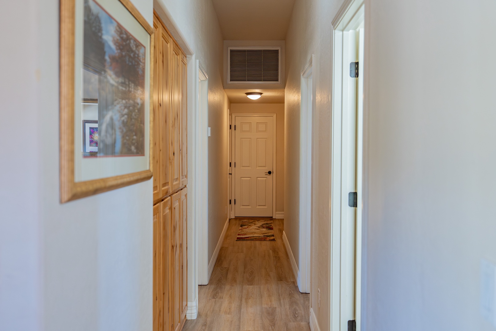 Your bright hallway features built-in storage and warm wood accents leading to cozy private spaces.