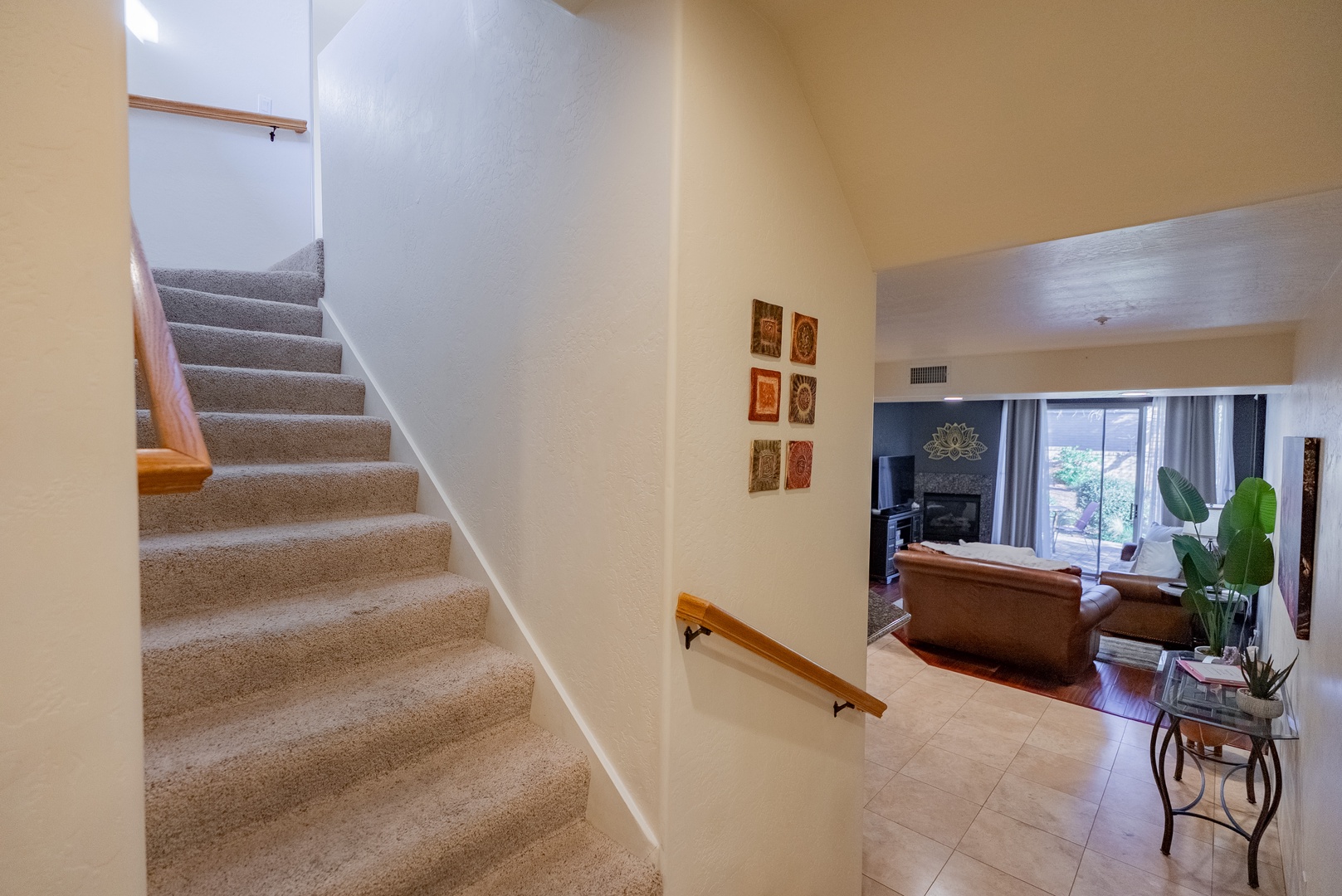 Your comfortable multi-level retreat features carpeted stairs with handrails, connecting to a bright living space with natural light and thoughtful decor.