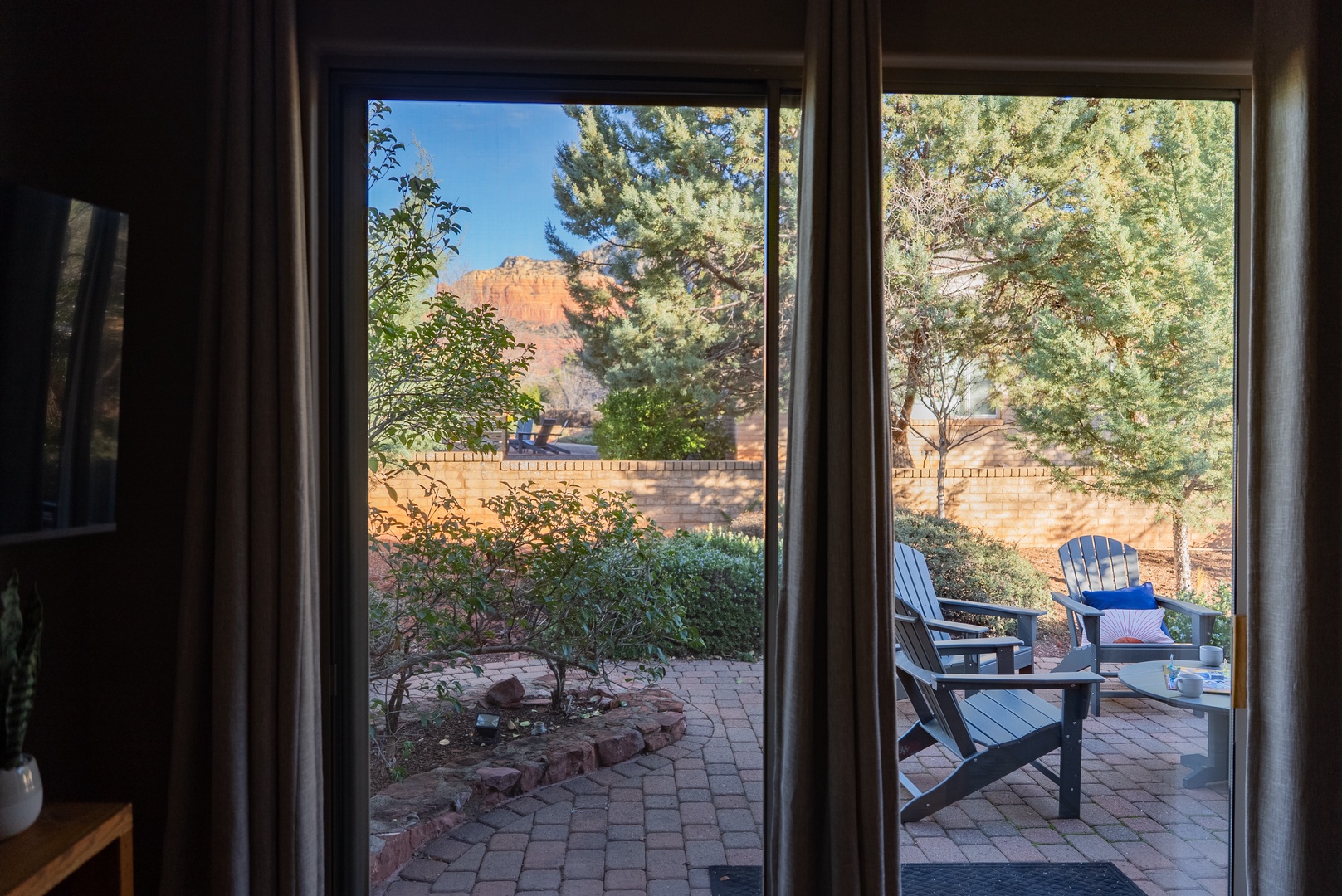 Step onto your private patio where Adirondack chairs await your morning coffee moments, surrounded by desert landscaping and stunning red rock views.