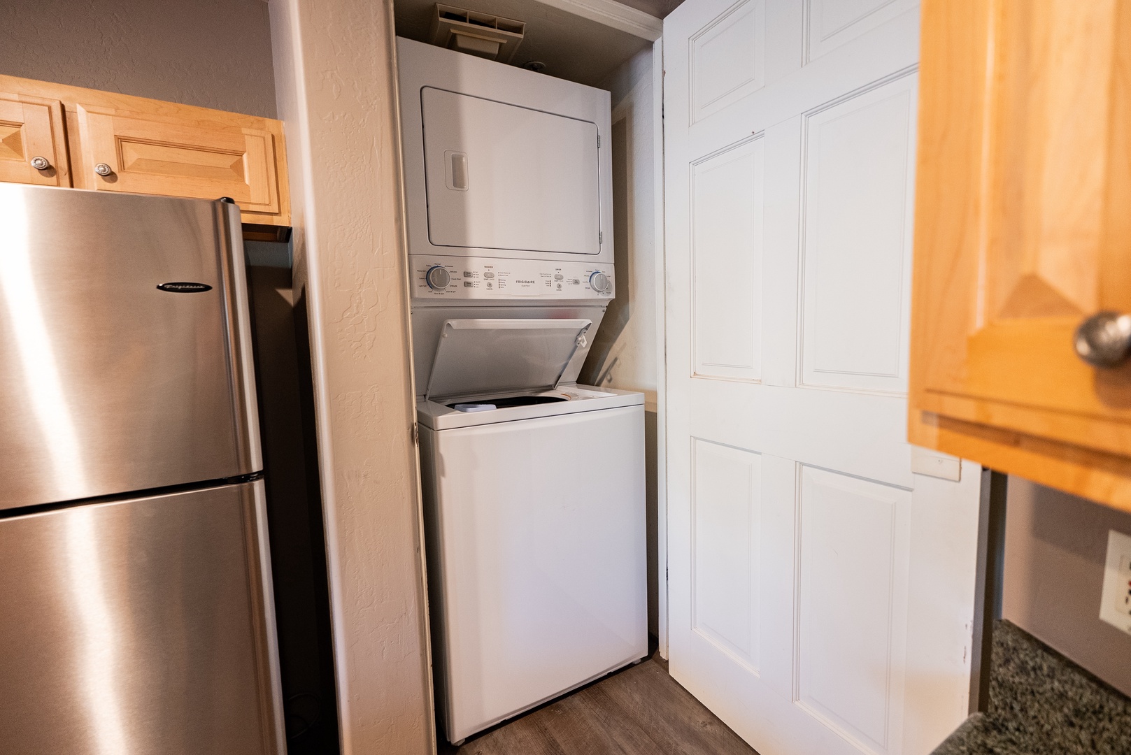 Stacked washer and dryer in closet by garage entrance