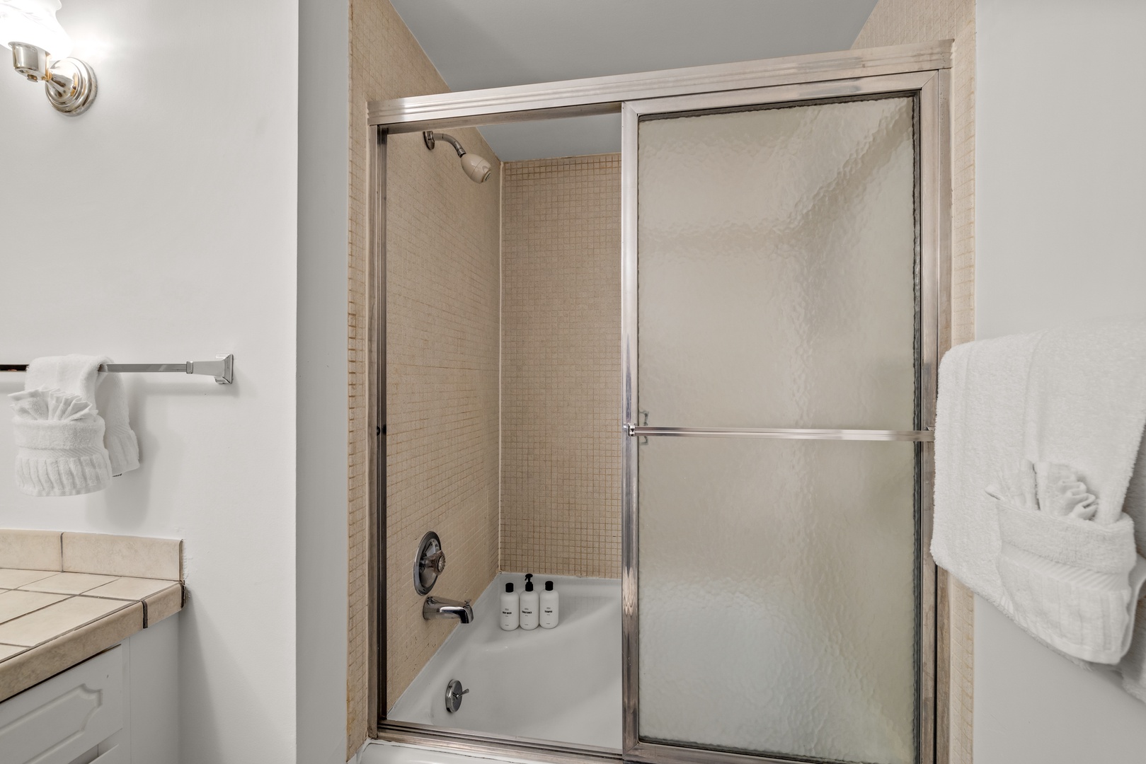 Your private bathroom features a spacious tub and shower combo, with fresh towels ready and complimentary toiletries provided for your comfort and convenience.